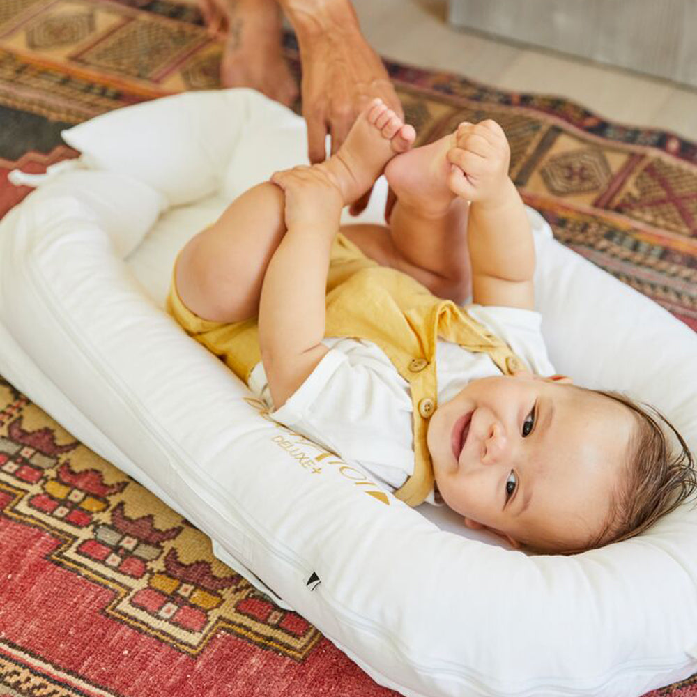 赤ちゃんがDockATot（プリスティンホワイト）で仰向け遊び中の様子