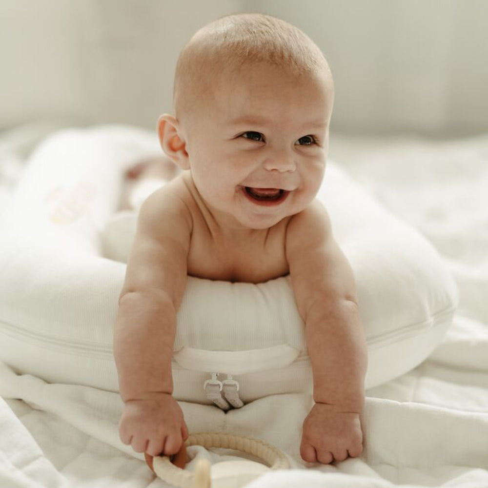 DockATotの上で笑顔の赤ちゃん｜柔らかいブランケット上での使用例