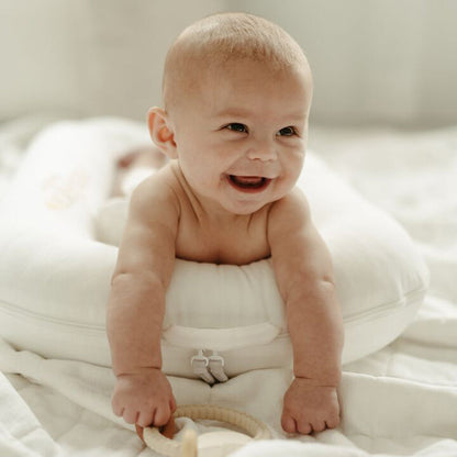 DockATotの上で笑顔の赤ちゃん｜柔らかいブランケット上での使用例