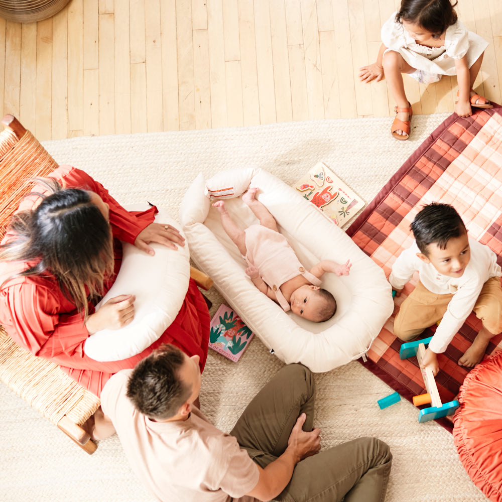 DockATot Deluxe+ Dock（サンドシャンブレー）リビングで家族のリラックスタイムの様子